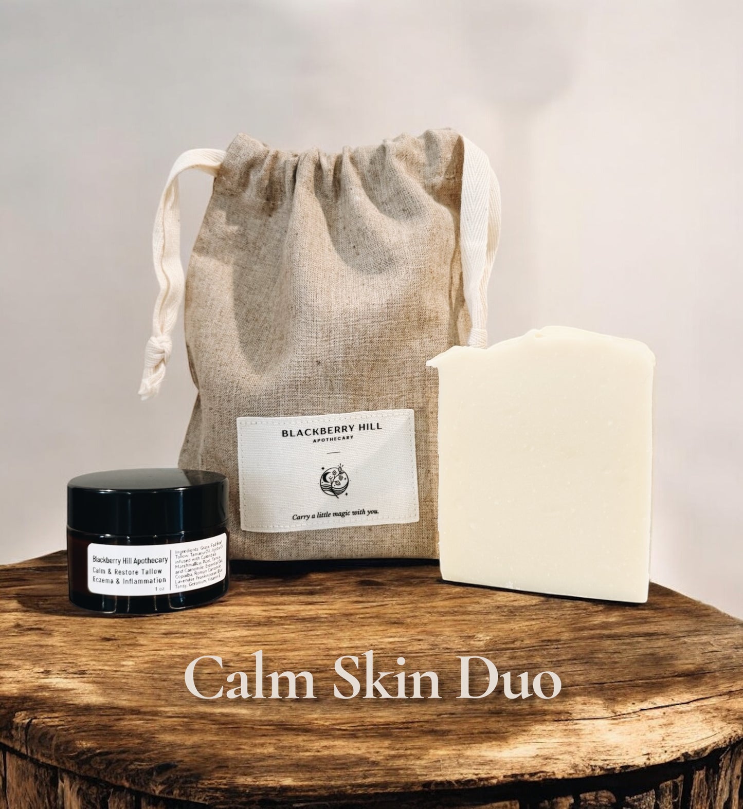 Calm Skin Duo with a jar, soap, and drawstring bag on a wooden surface.