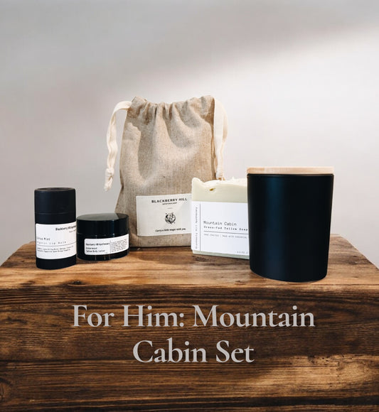 Grooming set for men with candles, soap, and a bag on a wooden surface.