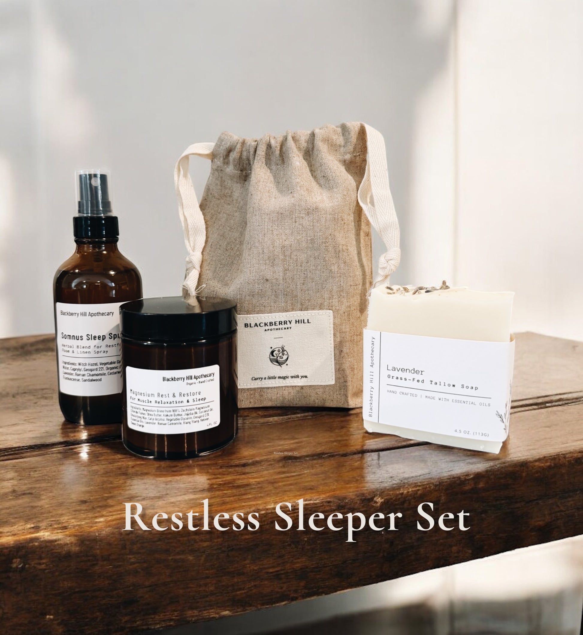 Set of natural products including a bottle, jar, and soap on a wooden surface with 'Blackberry Hill' branding.